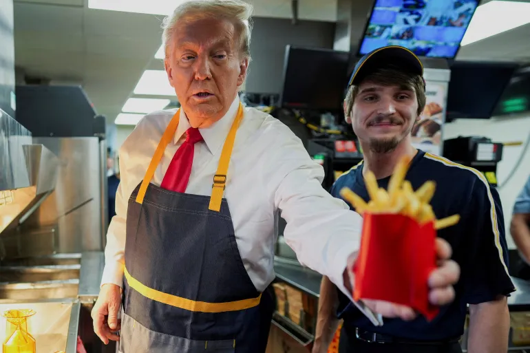 US Republican presidential candidate and former President Donald Trump works behind the counter during a visit to a McDonald's in Feasterville-Trevose, Pennsylvania, October 20