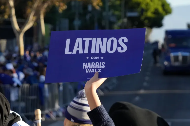 A Los Angeles Dodgers fan holds a sign endorsing Democratic presidential candidate Kamala Harris and vice presidential candidate Tom Walz that reads 'Latinos con Harris and Walz' during the 2024 World Series championship parade on November 1 in Los Angeles, California, the US