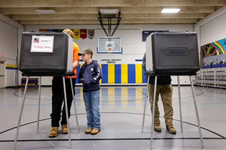 A boy watches his father vote in the 2024 US elections in Asheville, North Carolina, on November 5, 2024