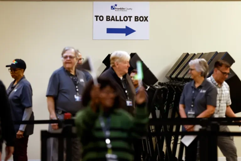 Poll workers wait to escort voters to the polling booths during the first day of in-person early voting at the Franklin County Board of Elections in Columbus, Ohio, the United States